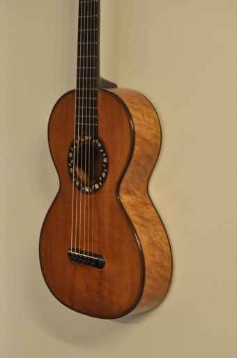 Three-quarter view of Thibouville-Lamy French romantic guitar showing spruce top and curly maple sides