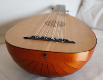 Close-up of the bridge and endpin area of the Le Luth Doré renaissance lute, showing string attachment and the bottom of the maple bowl