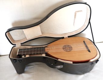 Le Luth Doré renaissance lute resting inside its original black hardshell case with beige velvet lining