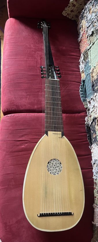 Front view of a theorbo built by José Miguel Moreno in 2021, showing the spruce soundboard with carved rosette and ebony bridge