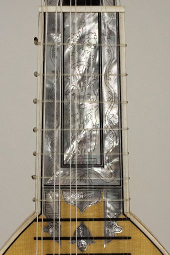 Engraved mother-of-pearl fingerboard of the Chiara Frisio Baroque mandolin with a figural scene and bone and ebony decoration
