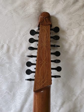Reverse of a Robert Hadaway bandora pegbox showing decorative line inlay and the carved hair of the human head