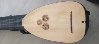 Spruce soundboard of an Anders Ahlborg theorbo with three carved rosettes, the bridge and a heart-shaped soundhole