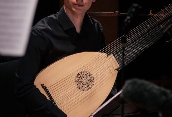 The György Lőrinczi archlute being played in concert, showing the body, carved rosette and diapason strings
