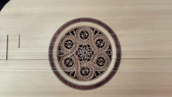 Detail of the multi-layered Stradivarius-type parchment rosette set in a rosewood ring on the spruce top