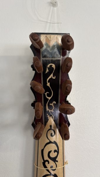 Pegbox of the Régis Floury baroque guitar with its ten turned wooden pegs and the marquetry decoration continuing down the neck