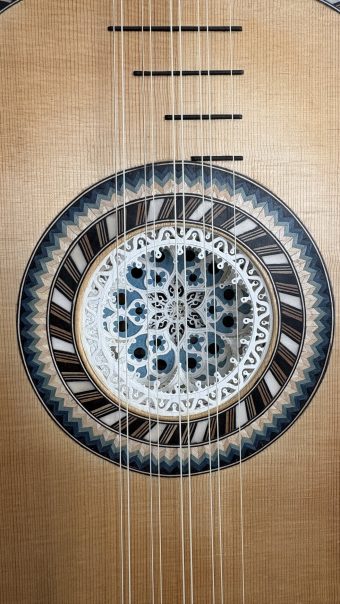 Close-up of the parchment rosette of the Régis Floury baroque guitar, built in layers and framed by concentric bands of geometric marquetry