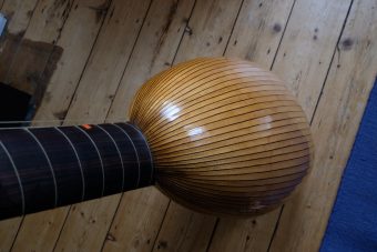 Back of the Jaume Bosser theorbo showing the ribbed bowl in light-coloured wood with dark fillets and the ebony neck with tied gut frets