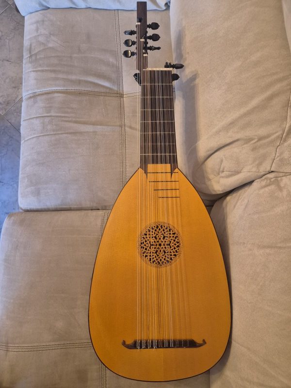 Full front view of a baroque lute by Jacob van de Geest (1971) with varnished soundboard, carved rosette and black pegs