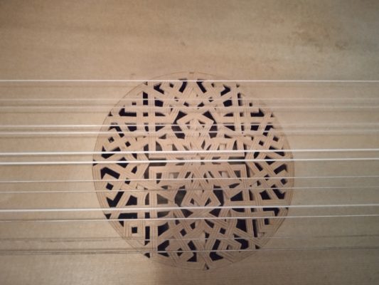 Close-up of the carved rose of the Mathias Durvie lute, with an interlaced geometric pattern under the strings
